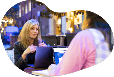 A sales coaching session between a manager and a rep at a cafeteria table