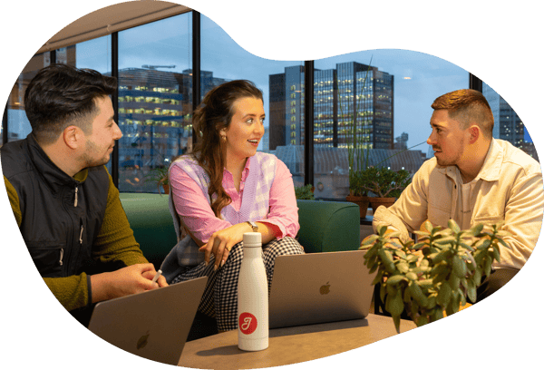 Three Jiminny employees working in an open-plan office
